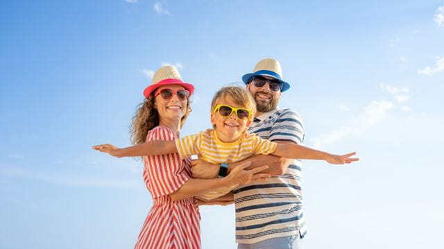 Mum and dad holding their child on a beach